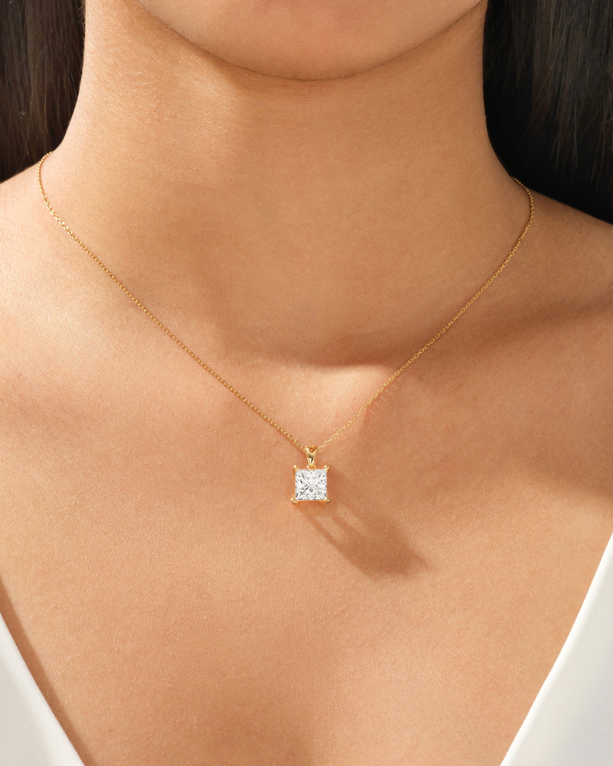 Gold necklace with princess cut diamond pendant on model