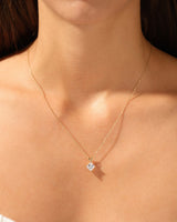Gold necklace with diamond pendant on a woman's neck
