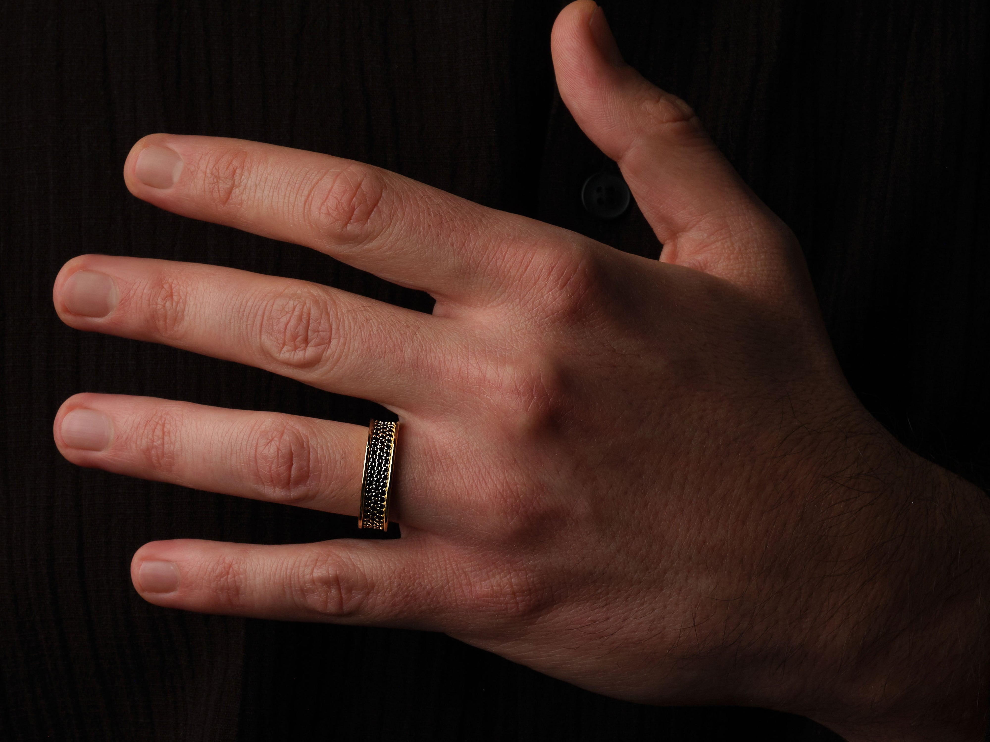 Gold ring with black stones on a man's hand