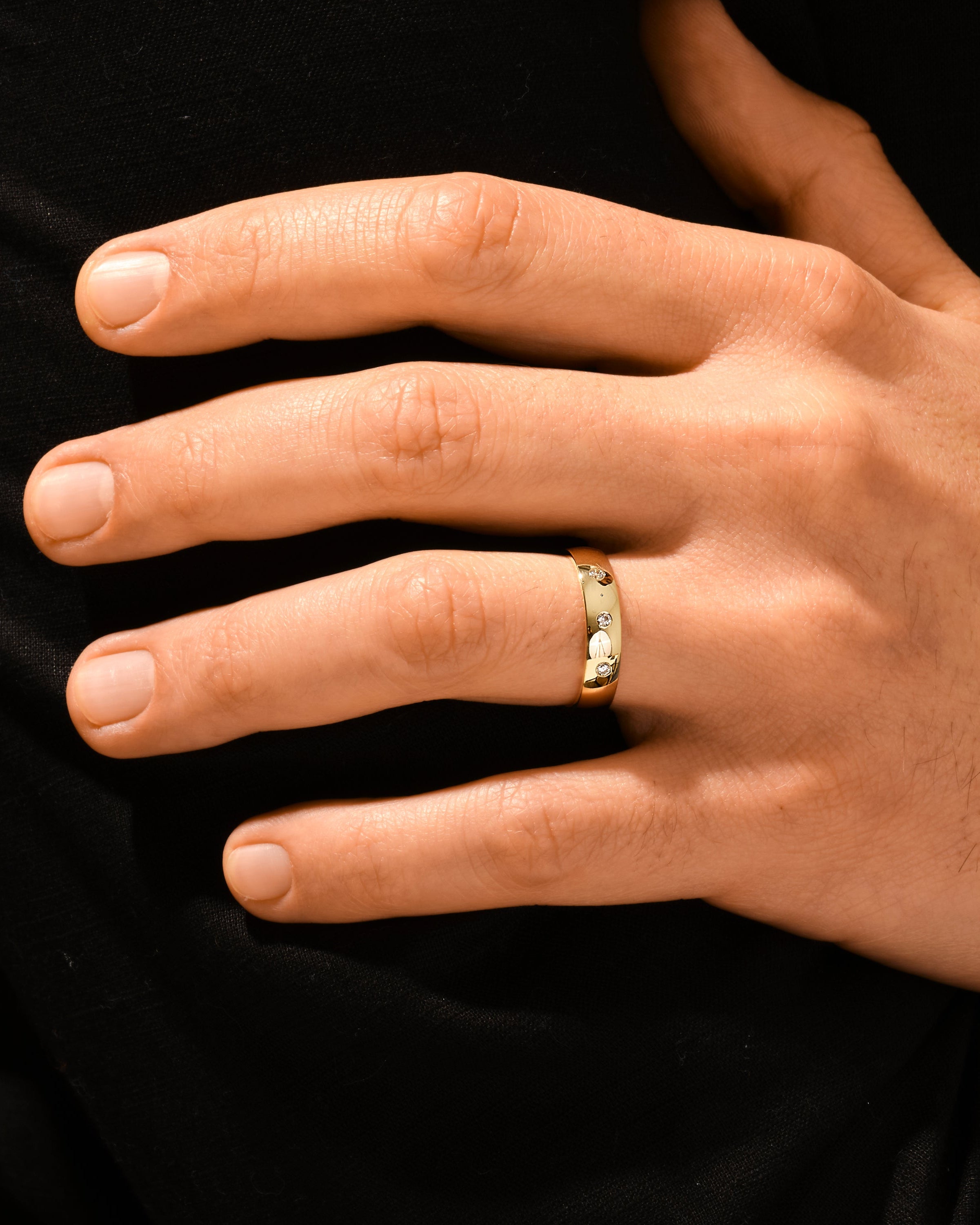 Gold ring with diamonds on a man's finger
